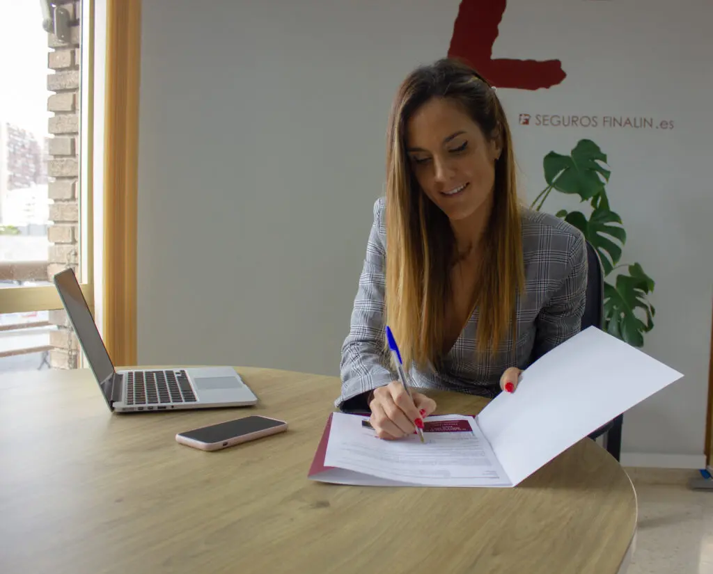 mujer firmando una póliza de seguros